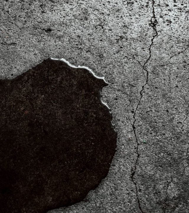 Detailed image of a wet cracked concrete surface with visible texture.